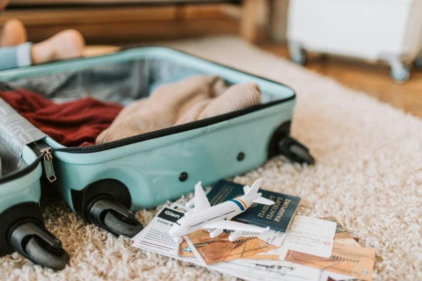 Packed suitcase with passport, boarding pass, and cash showing travel preparation and savings from smart travel deals.