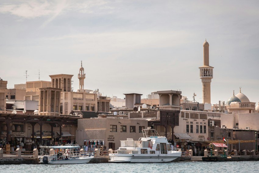 Old Dubai Creek waterfront with traditional buildings, boats, and heritage markets, a classic Things to Do in Dubai experience.