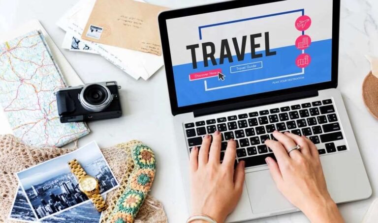 TravelTweaks.com travel planning guide open on laptop with maps, camera, and travel photos on a desk.