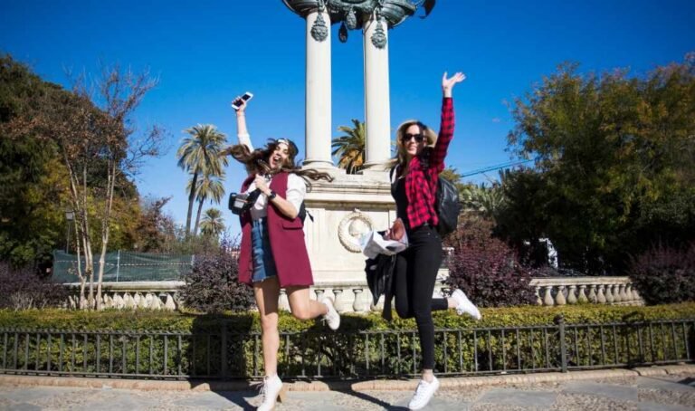 Two friends jumping happily in Paris on a sunny day, adding a fun travel moment to a Fun Facts About Paris guide.