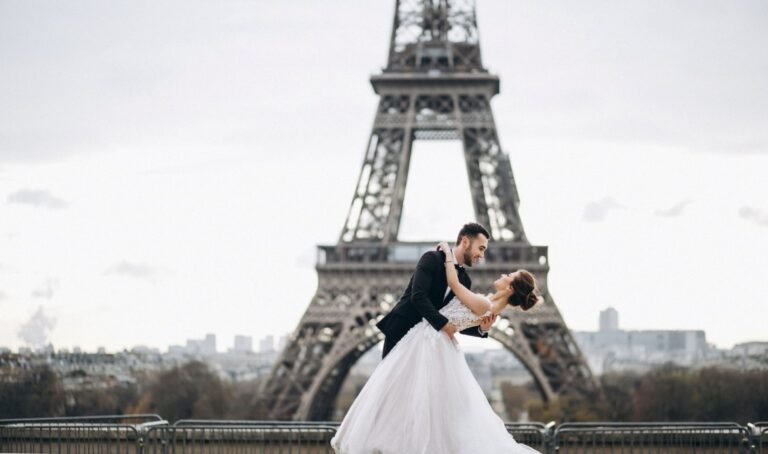 Bride and groom posing before the Eiffel Tower, reflecting why Paris is the City of Love.